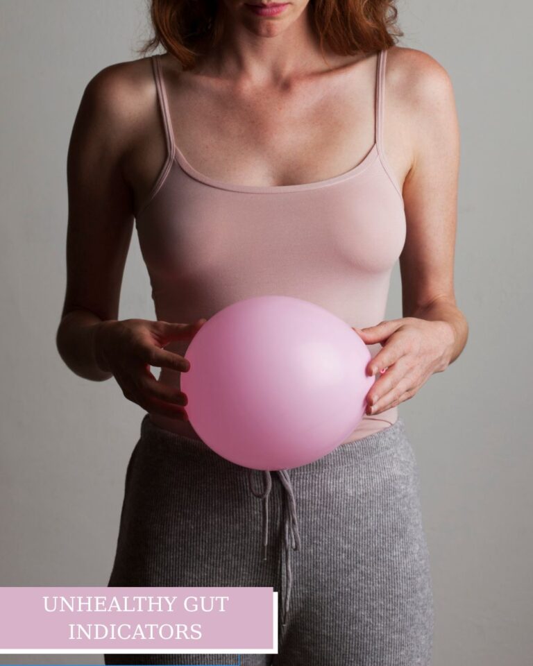 Woman in a pink tank top holding a pink balloon over her stomach, symbolizing bloating and symptoms of an unhealthy gut.